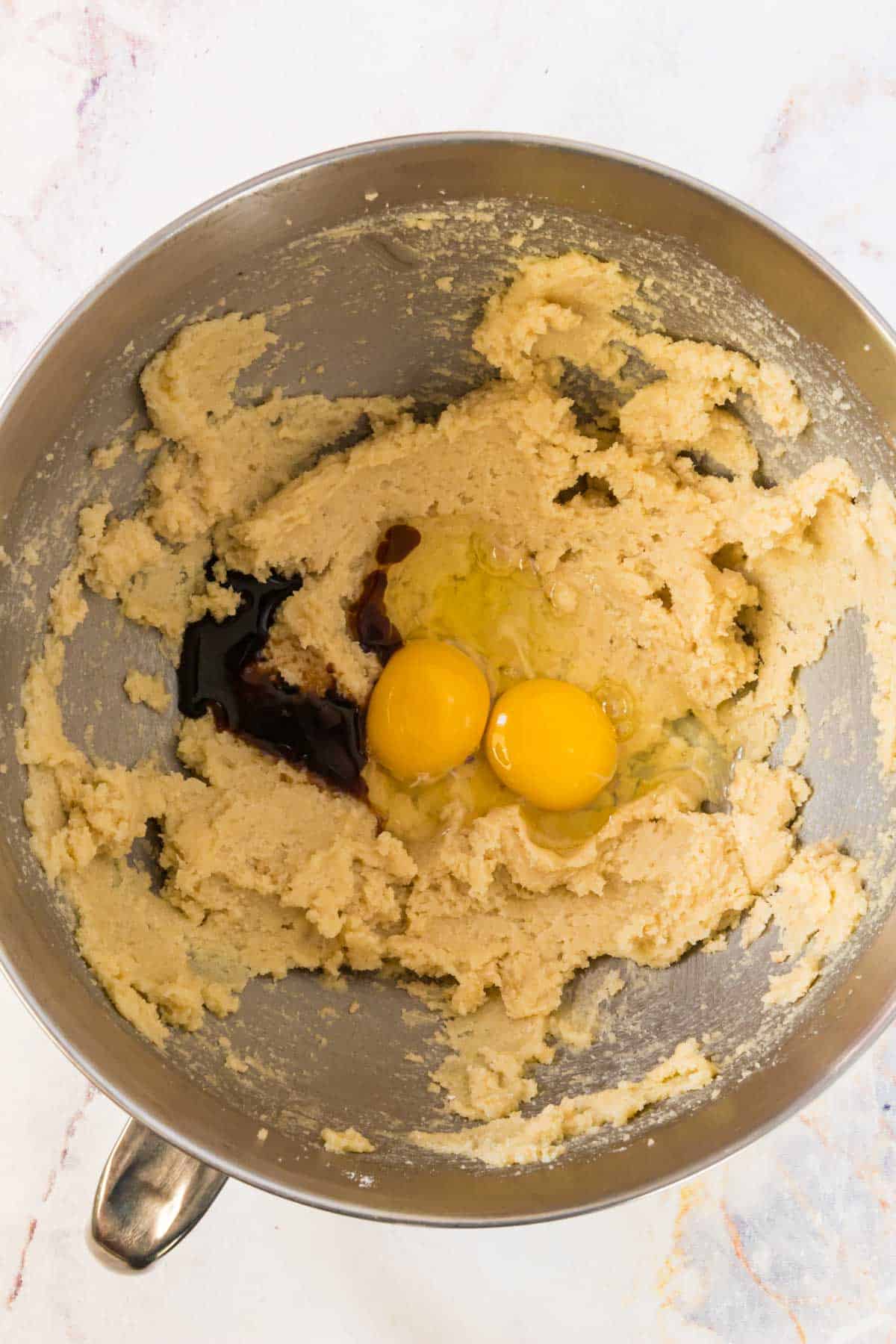 Eggs are added into the butter and sugar for cookie dough.