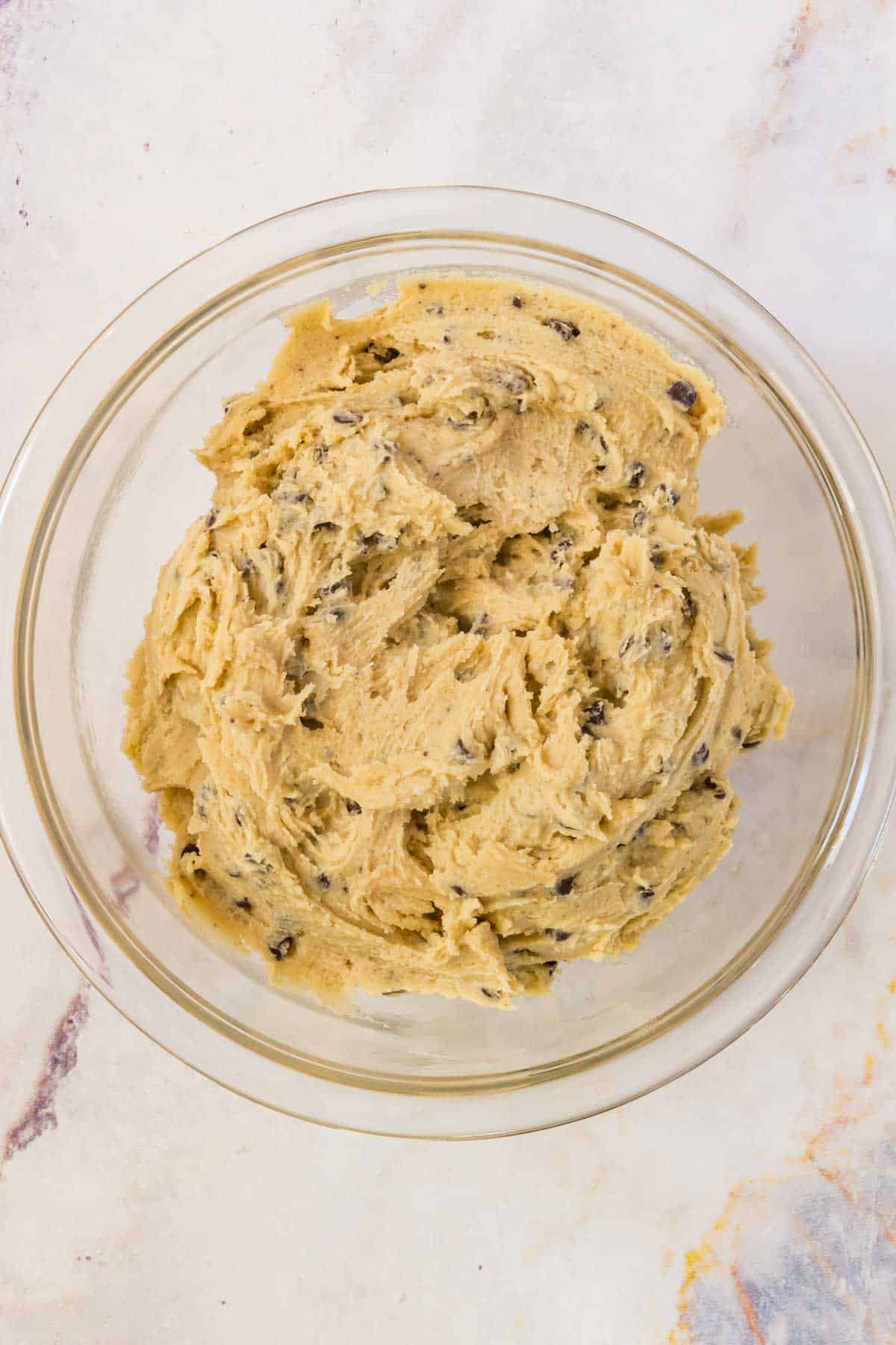 Gluten free chocolate chip cookie dough in a glass mixing bowl.