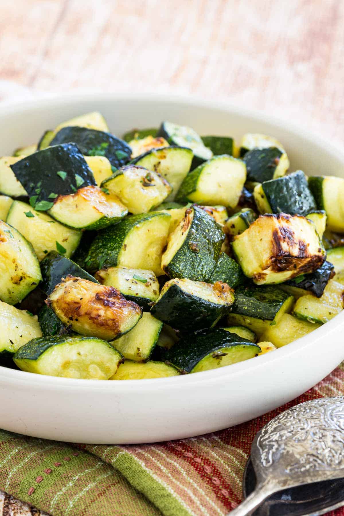 Roasted air fryer zucchini pieces in a white serving bowl.