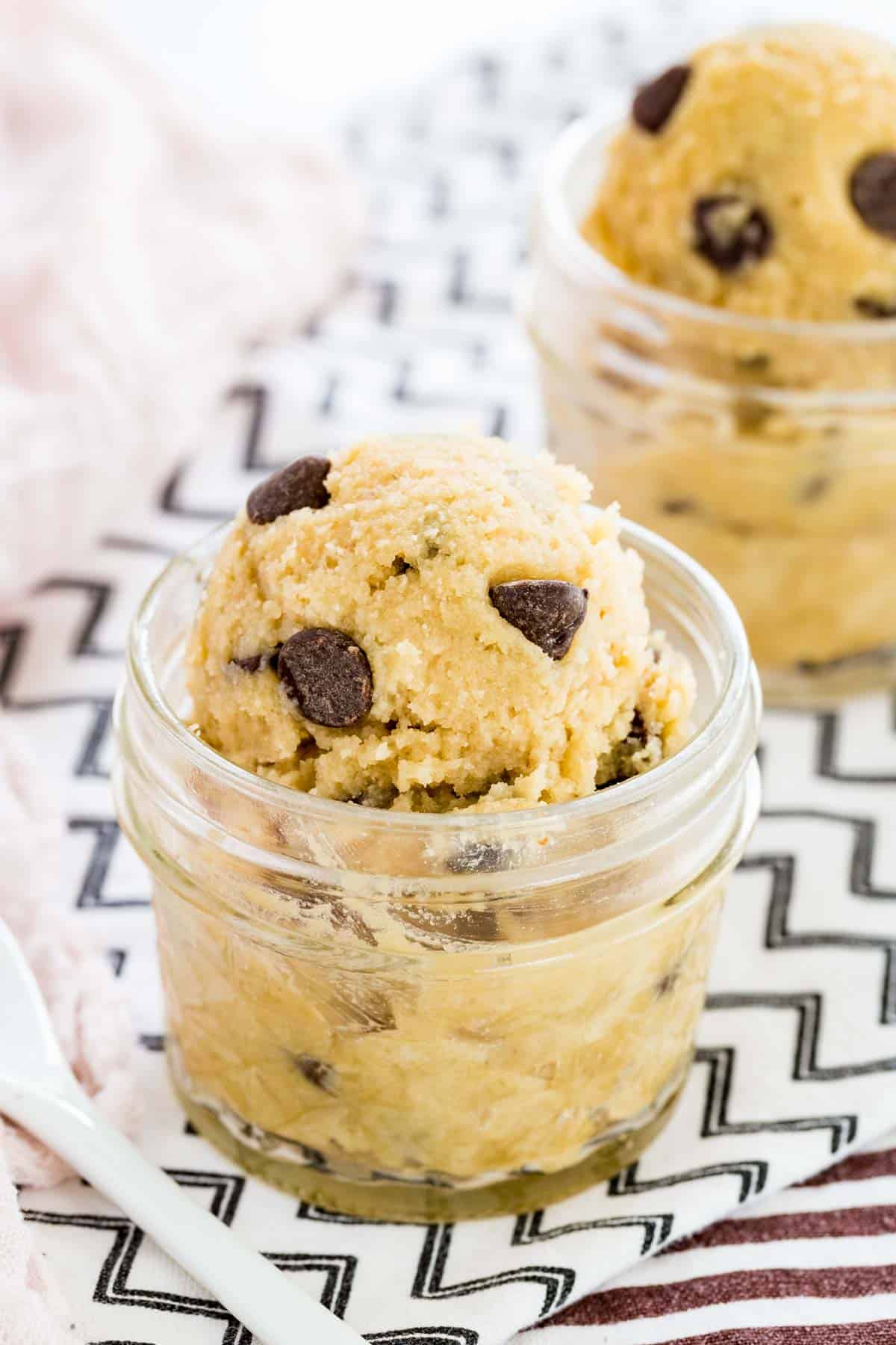 Scoops of gluten-free chocolate chip cookie dough in a glass mason jar.