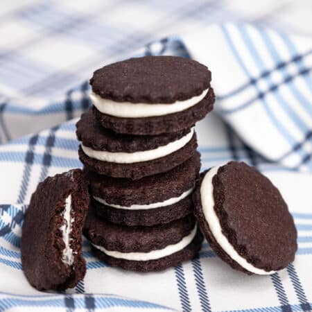 A stack of gluten free Oreos on a blue checked cloth.