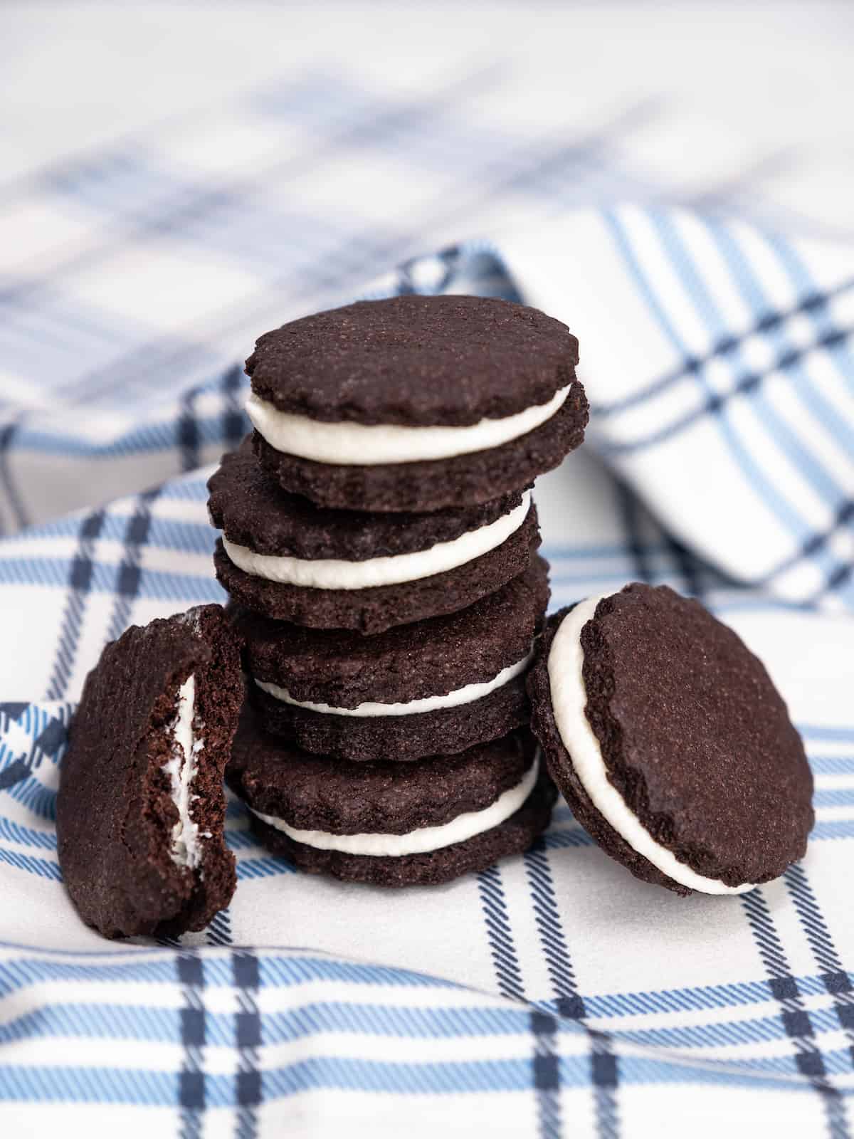 A stack of gluten free Oreos on a blue checked cloth.