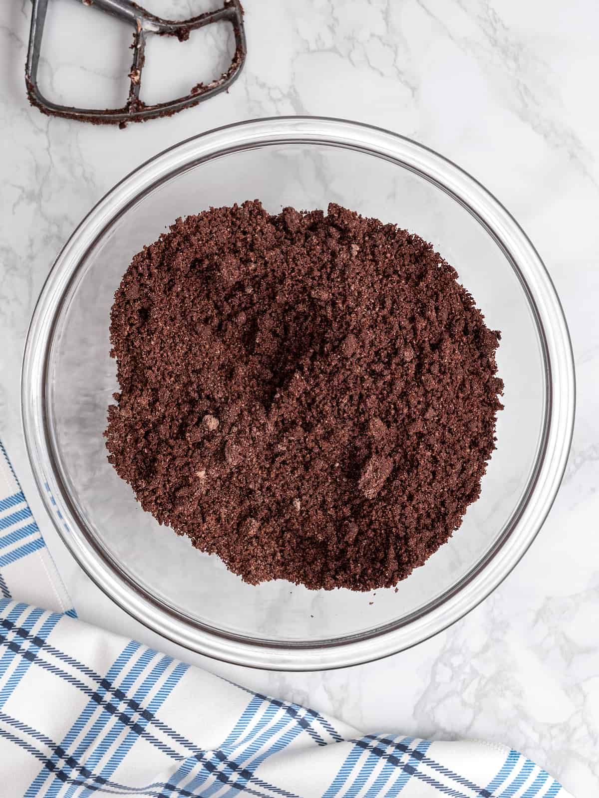 Chocolate cookie dough comes together in a glass mixing bowl.