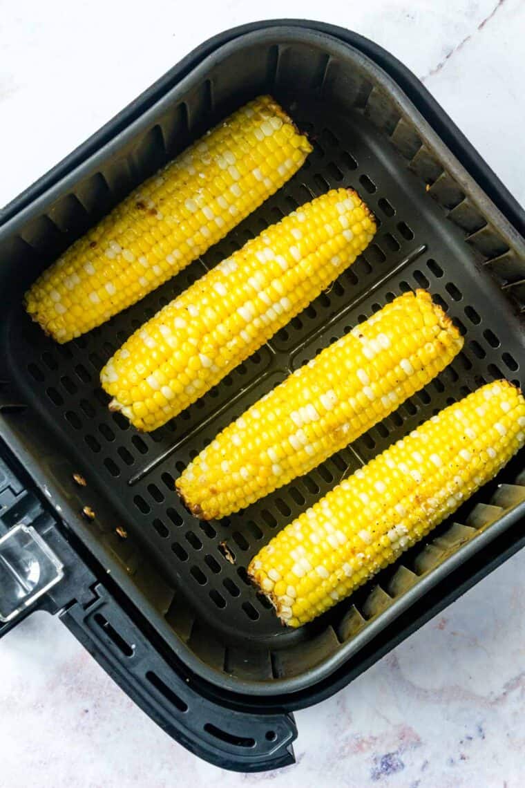 Top view of roasted corn on the cob inside the air fryer.