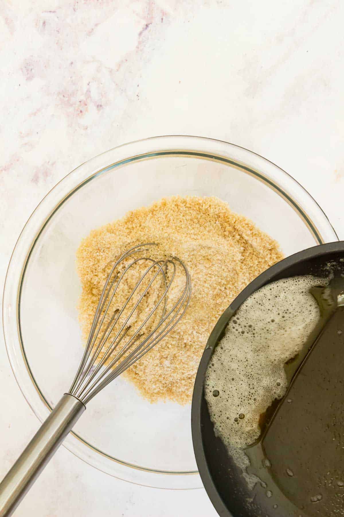 Browned butter is added into a bowl with the dry ingredients for cookie dough.