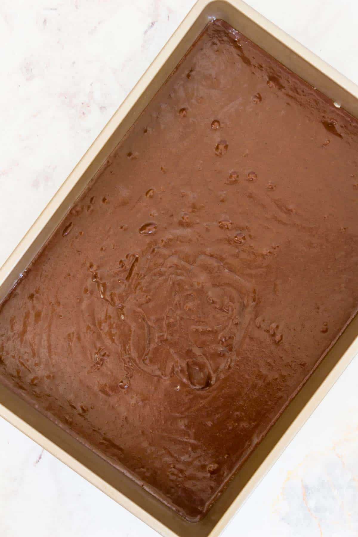 A large rectangular baking pan filled with brownie batter.