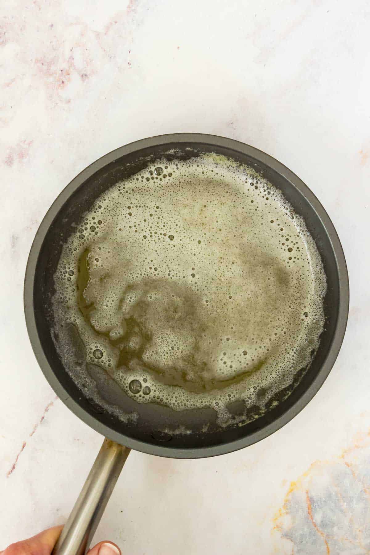 Browned butter bubbles in a saucepan.