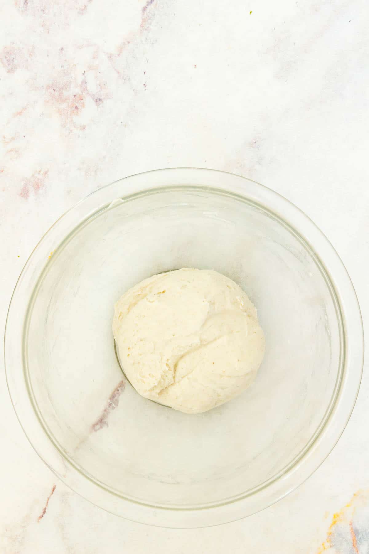 Gluten free tortilla dough in a clear mixing bowl.