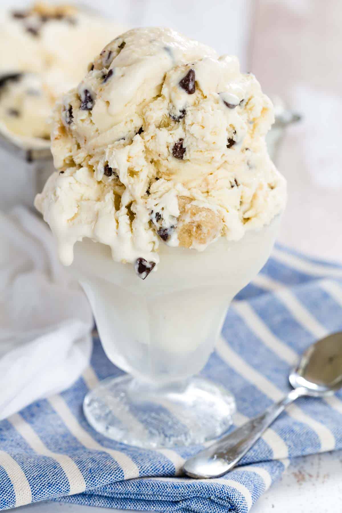 Chocolate chip cookie dough no-churn ice cream served in a fountain glass, with melted ice cream running down the sides.