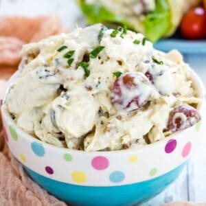 Chicken salad with grapes in a blue bowl that has a polka dot rim.