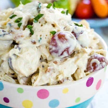 Chicken salad with grapes in a blue bowl that has a polka dot rim.