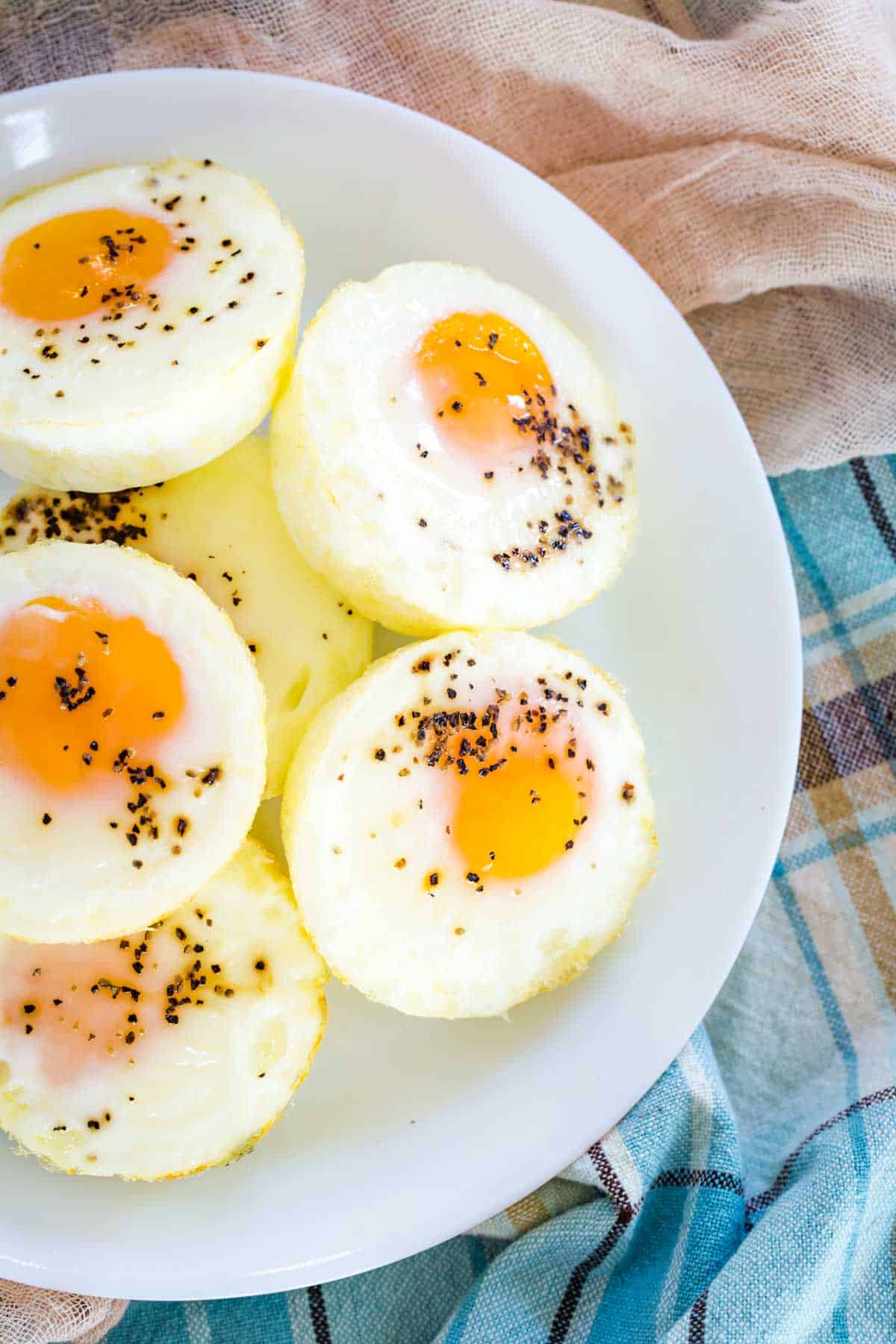 Top view of seasoned baked eggs stacked on a plate.