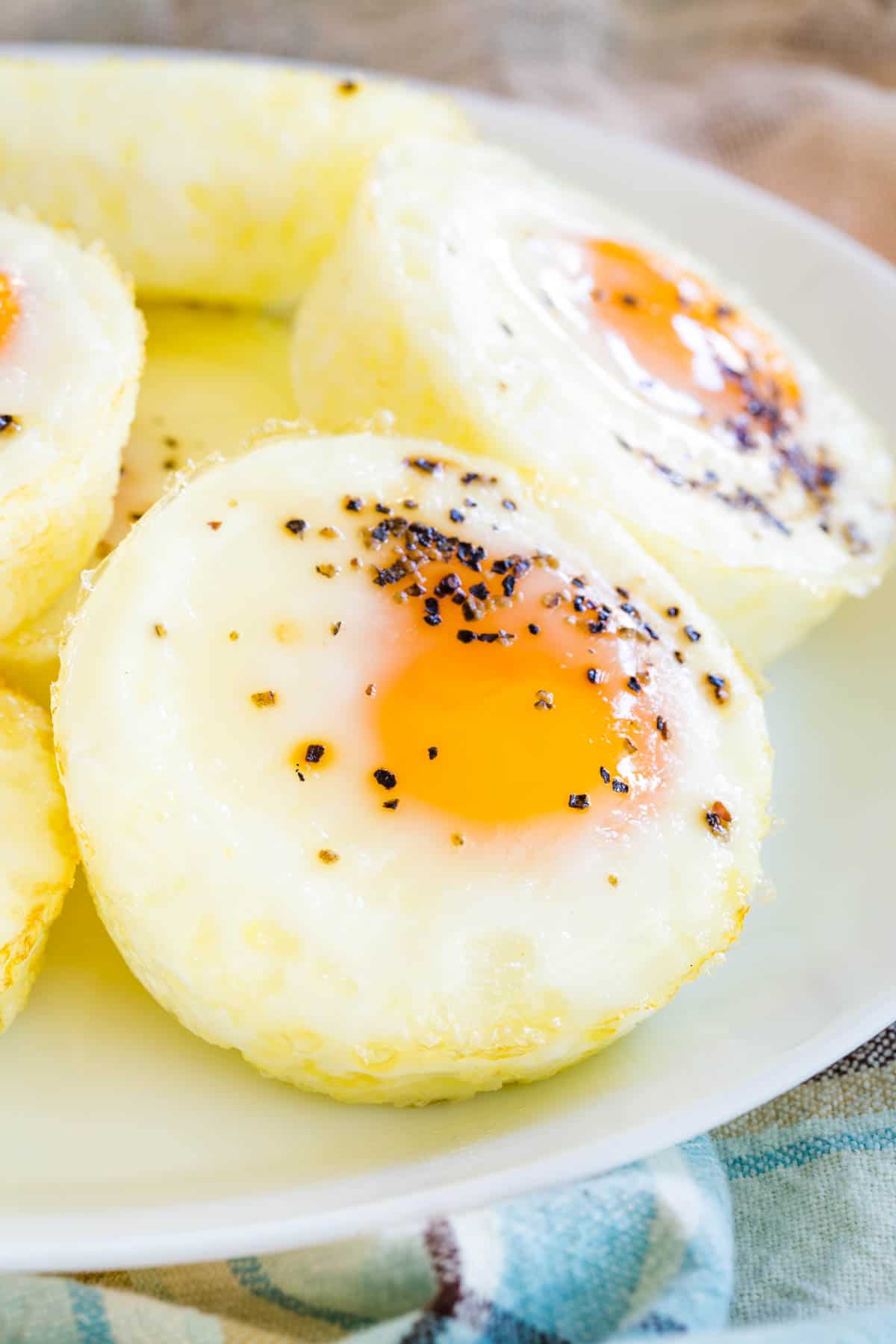 Close up of seasoned baked eggs stacked on a plate.