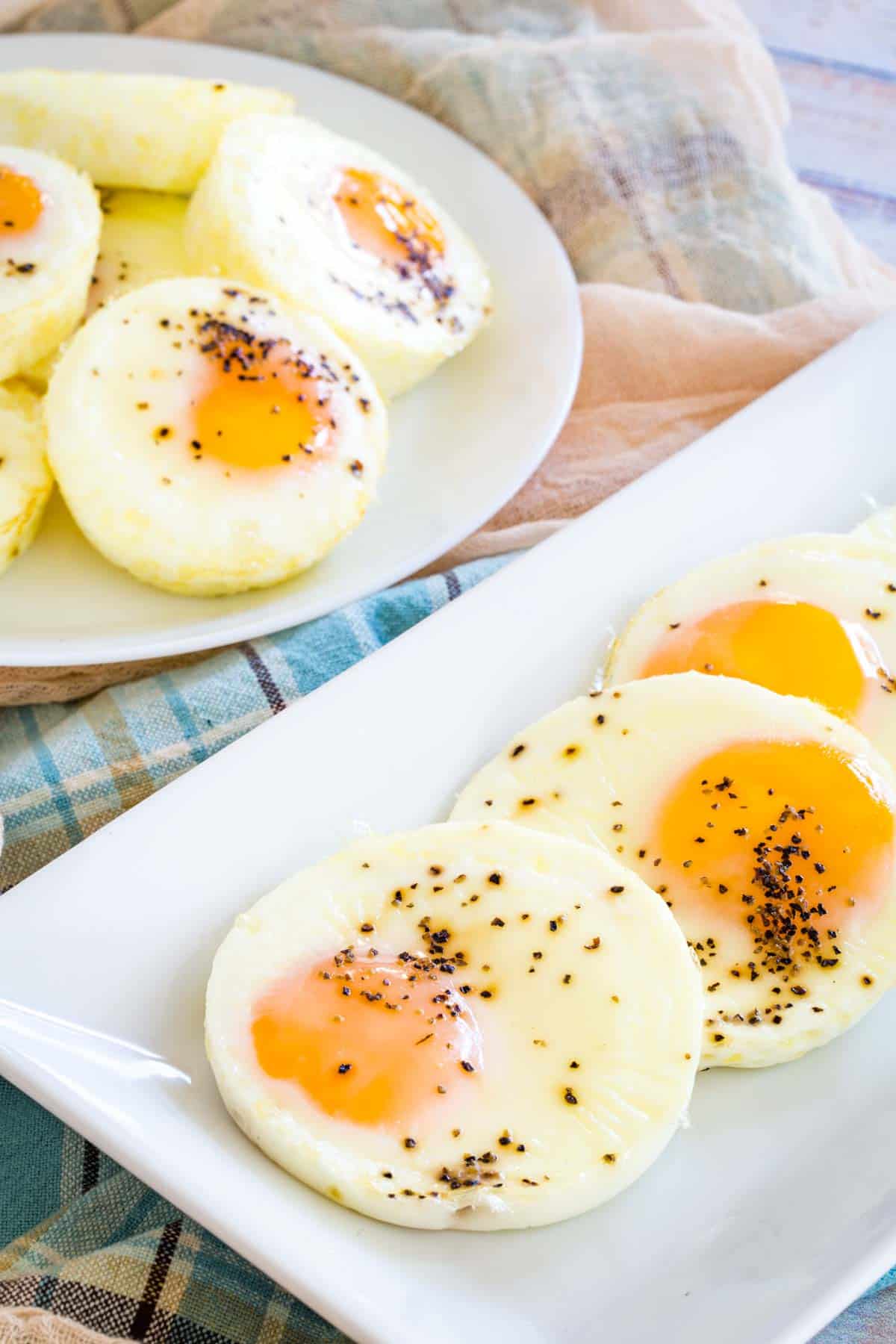 A rectangular platter of seasoned baked eggs with a plate full of baked eggs in the background.