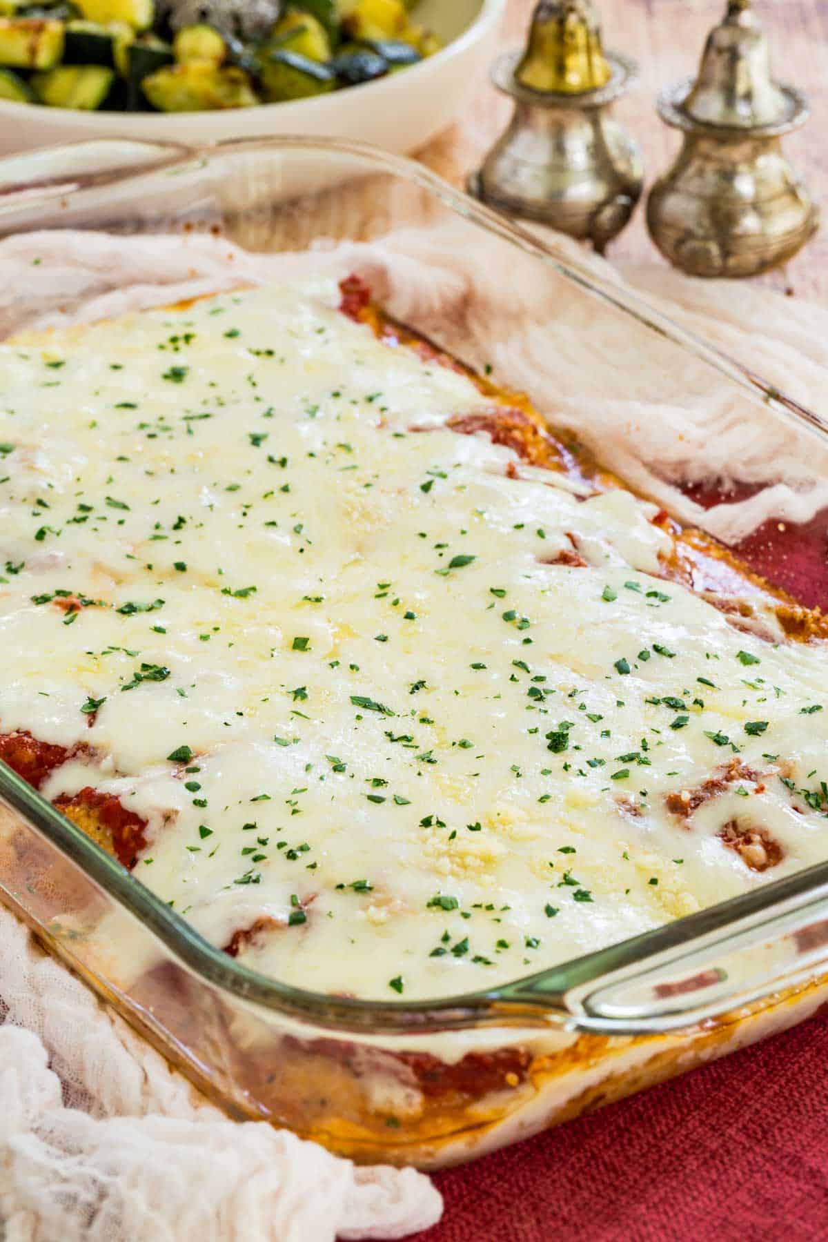 Baked chicken parmesan in a glass casserole dish.
