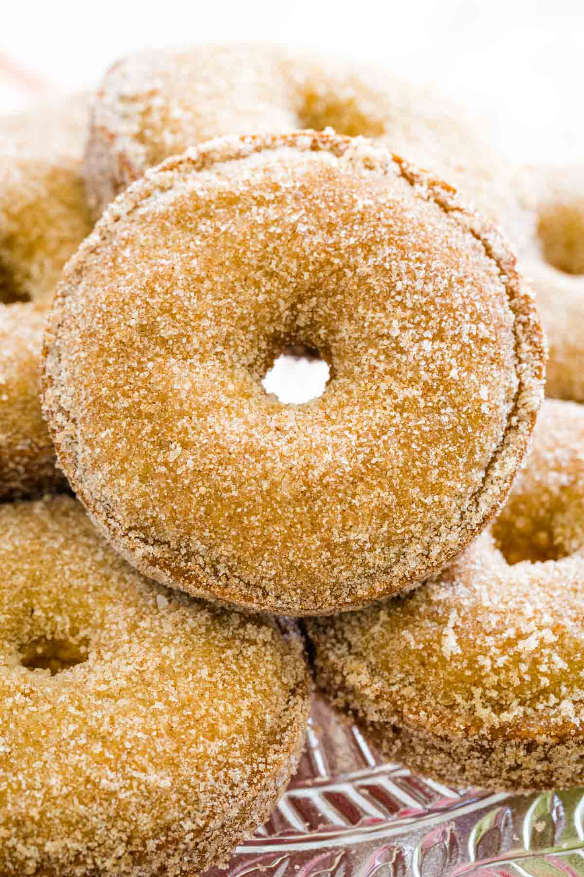 Close up of gluten free apple cider donuts on a cake stand.