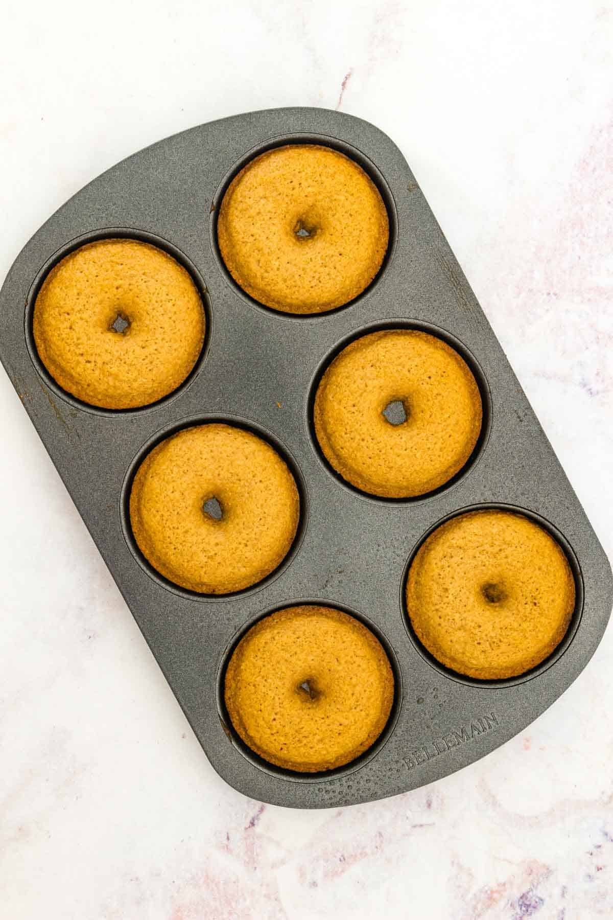 Baked gluten free apple cider donuts in a donut pan.