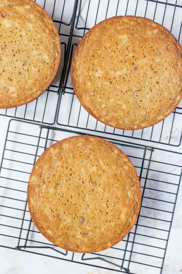 Three hummingbird cake layers on colling racks.