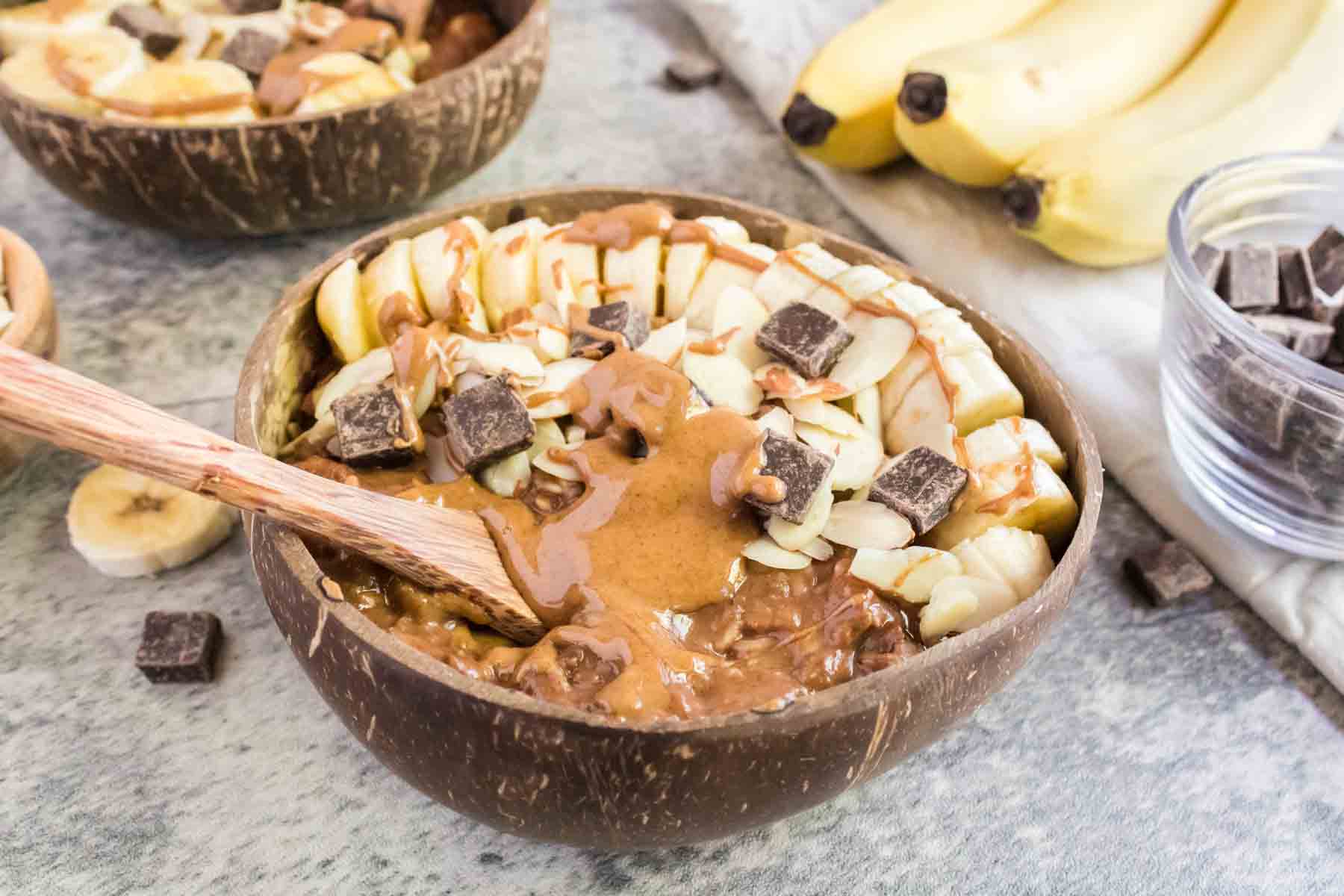 A heaping bowl full of chocolate oatmeal with various toppings.