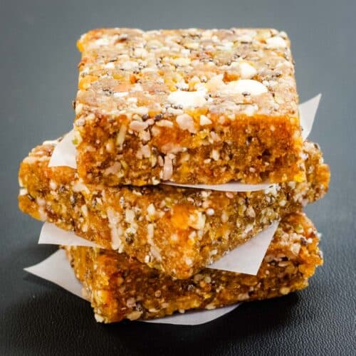 A stack of three apricot energy bars separated by a small piece of wax paper.