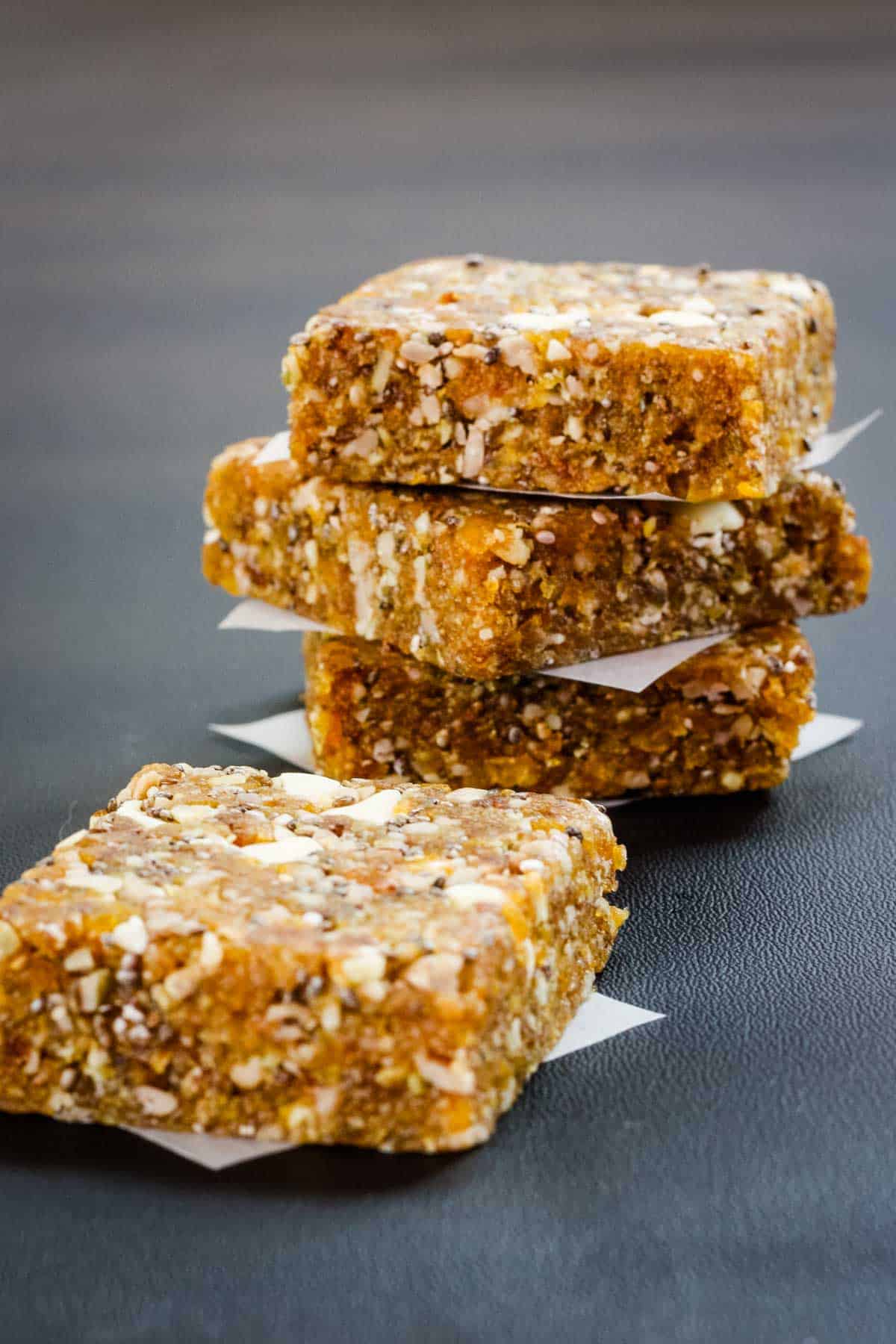 Three stacked apricot energy bars with one out of focus in front.