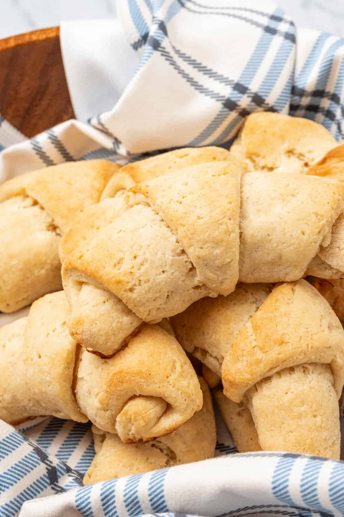 Assorted gluten free crescent rolls nestled in a bowl lined with a dishcloth.
