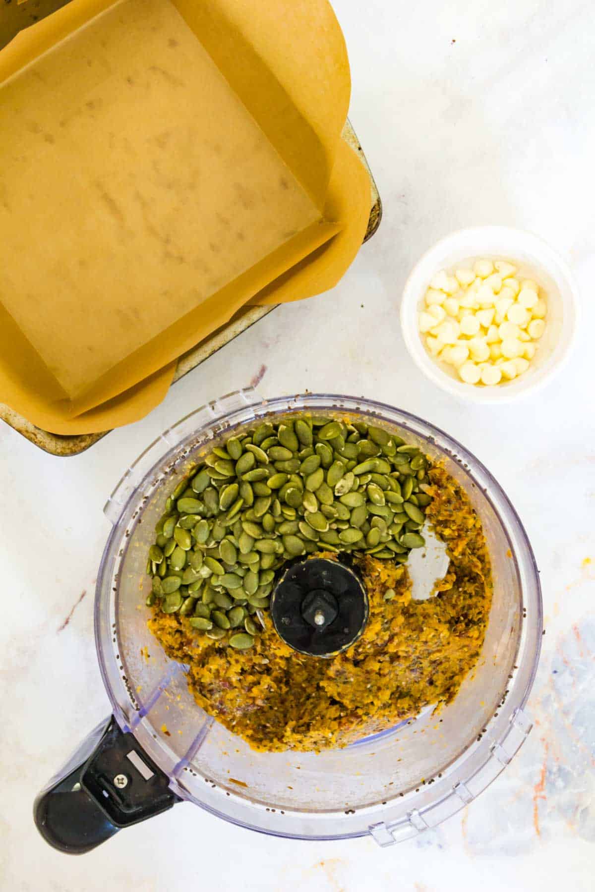 The energy bar mixture in the food processor with pumpkin seeds added to it.