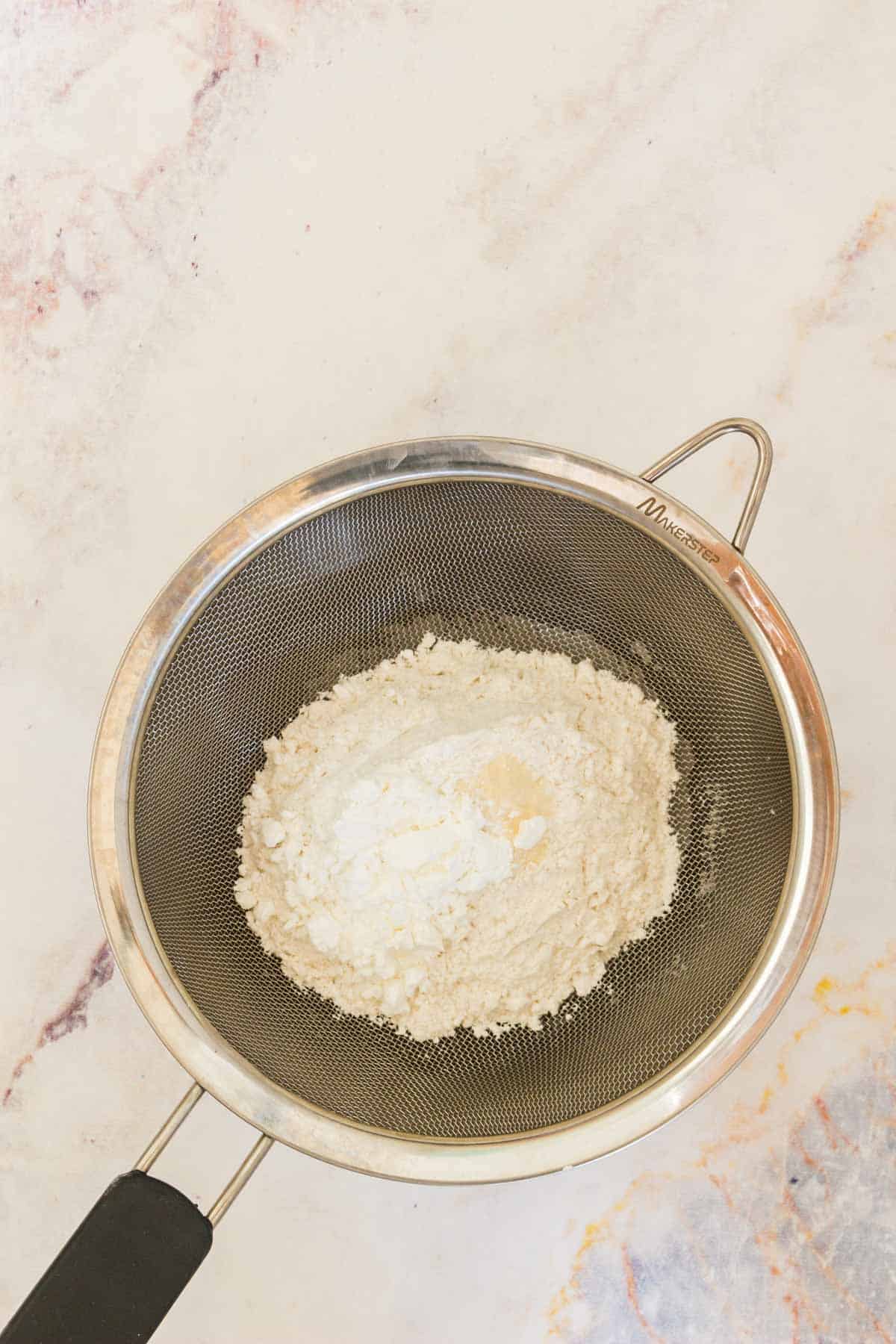 Flour and dry ingredients are passed through a sifter.