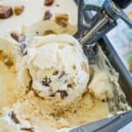 No-churn Reese's ice cream is scooped from a loaf pan with a large ice cream scoop.