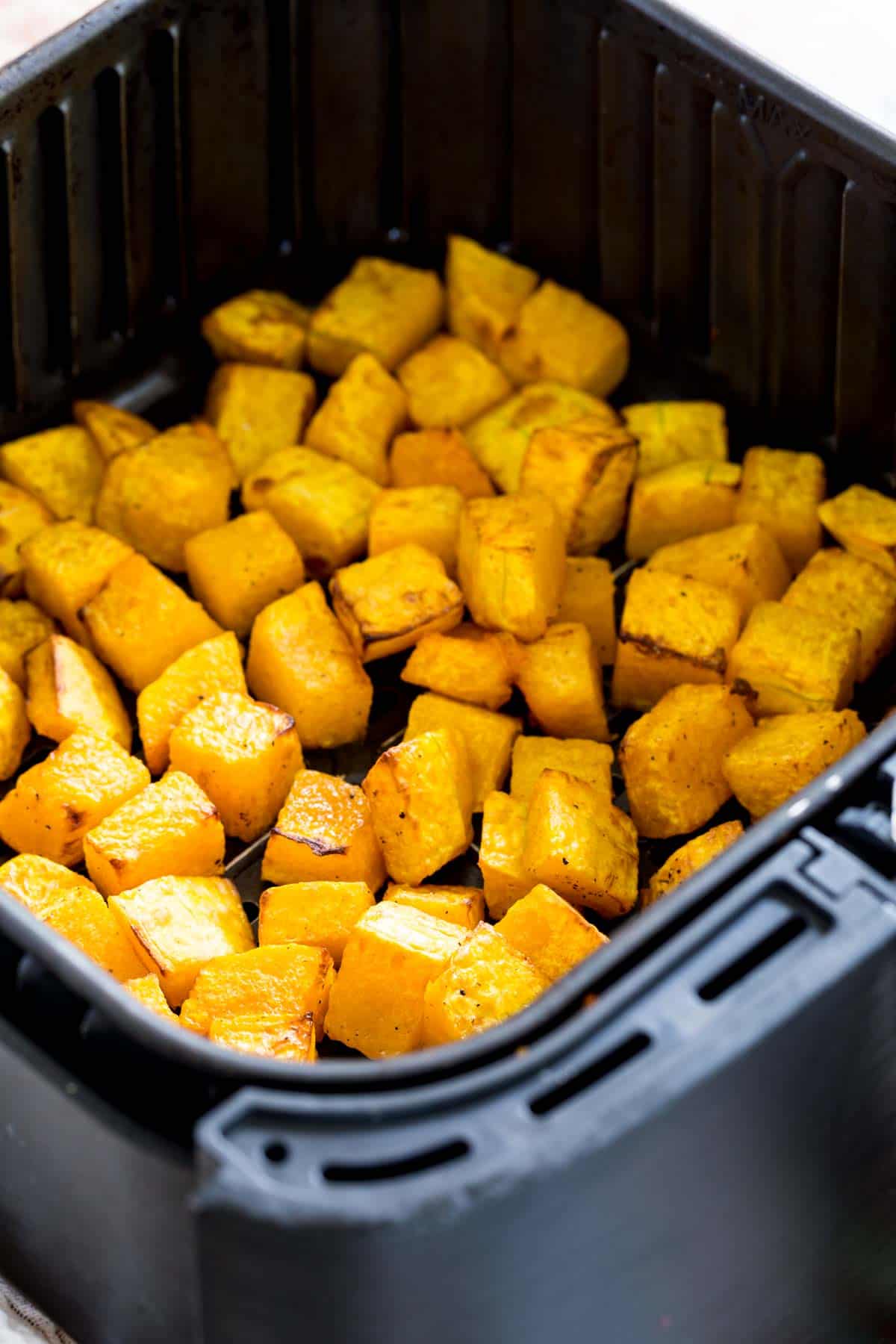 Cubed butternut squash inside the air fryer.