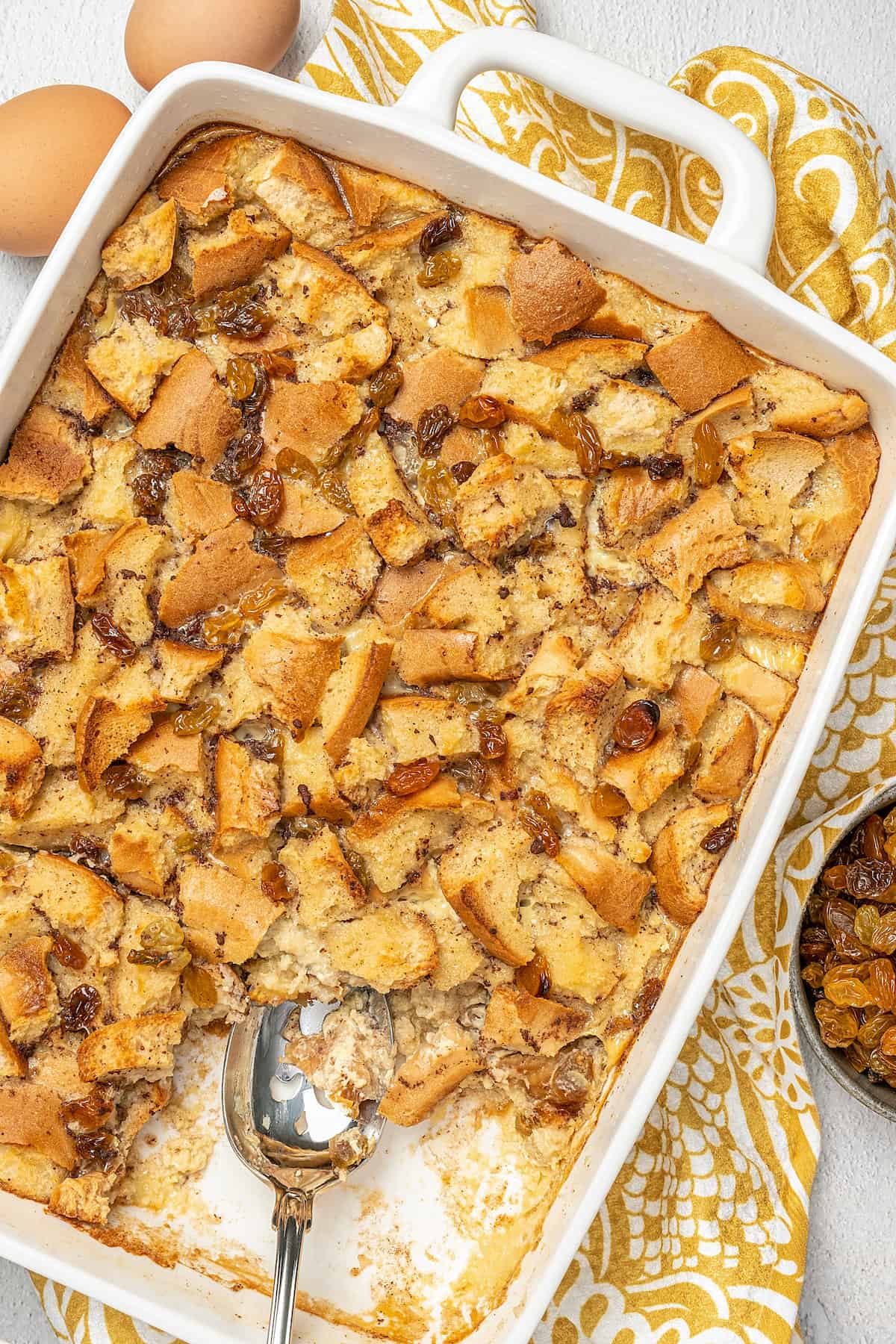 Gluten-free bread pudding in a baking dish with a serving missing.