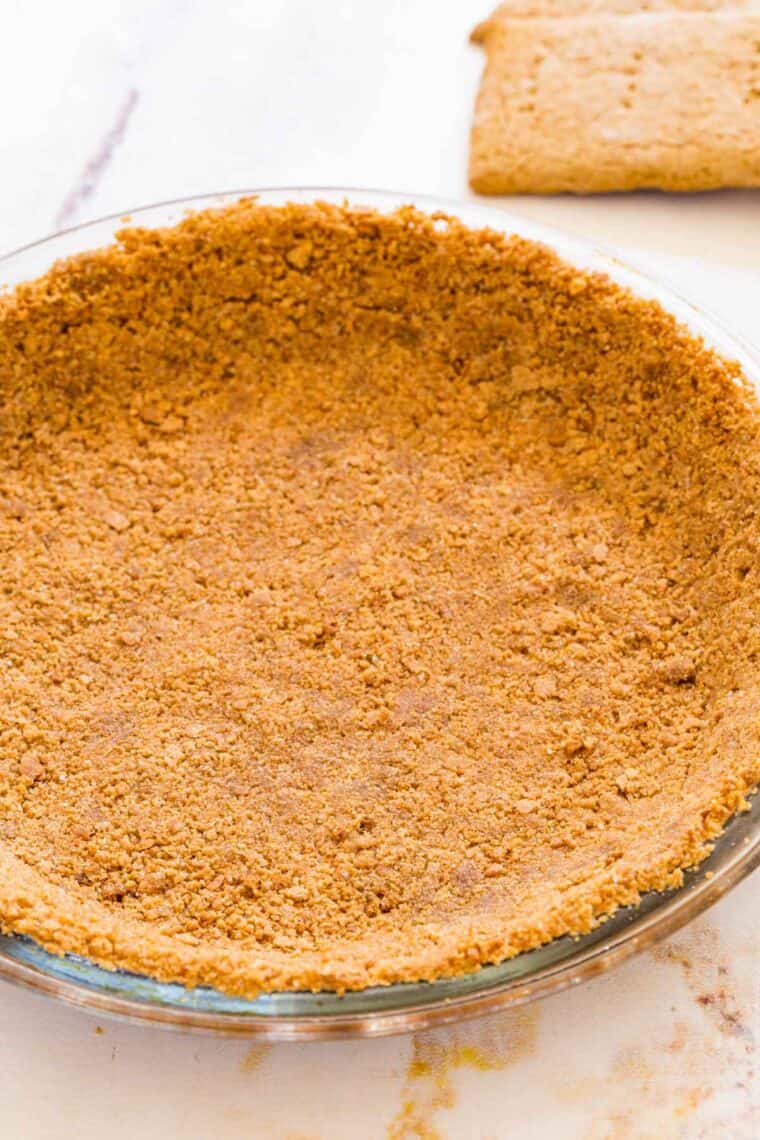 Gluten-free graham cracker crust pressed into a glass pie plate.