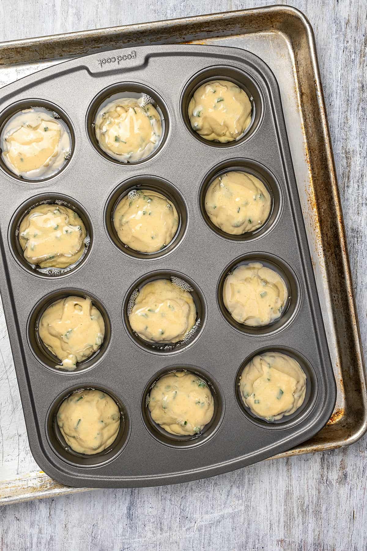 Overhead view of a 12-well muffin tin filled with Yorkshire pudding batter.
