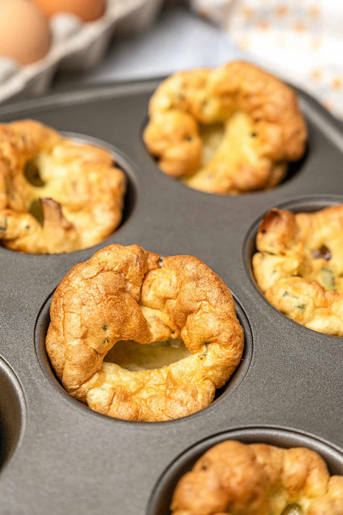 Close up of baked gluten-free Yorkshire puddings in a muffin tin.