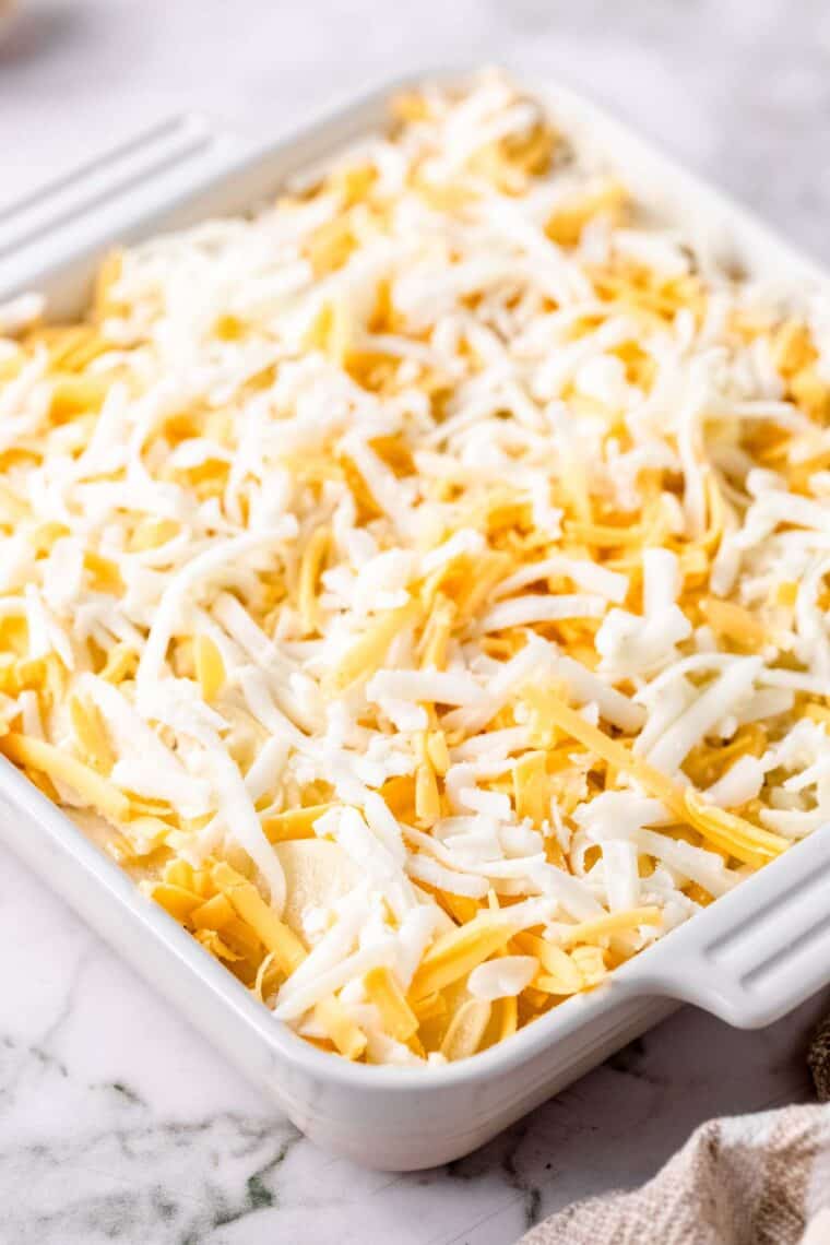 Assembled scalloped potatoes in a baking dish, ready to be baked.