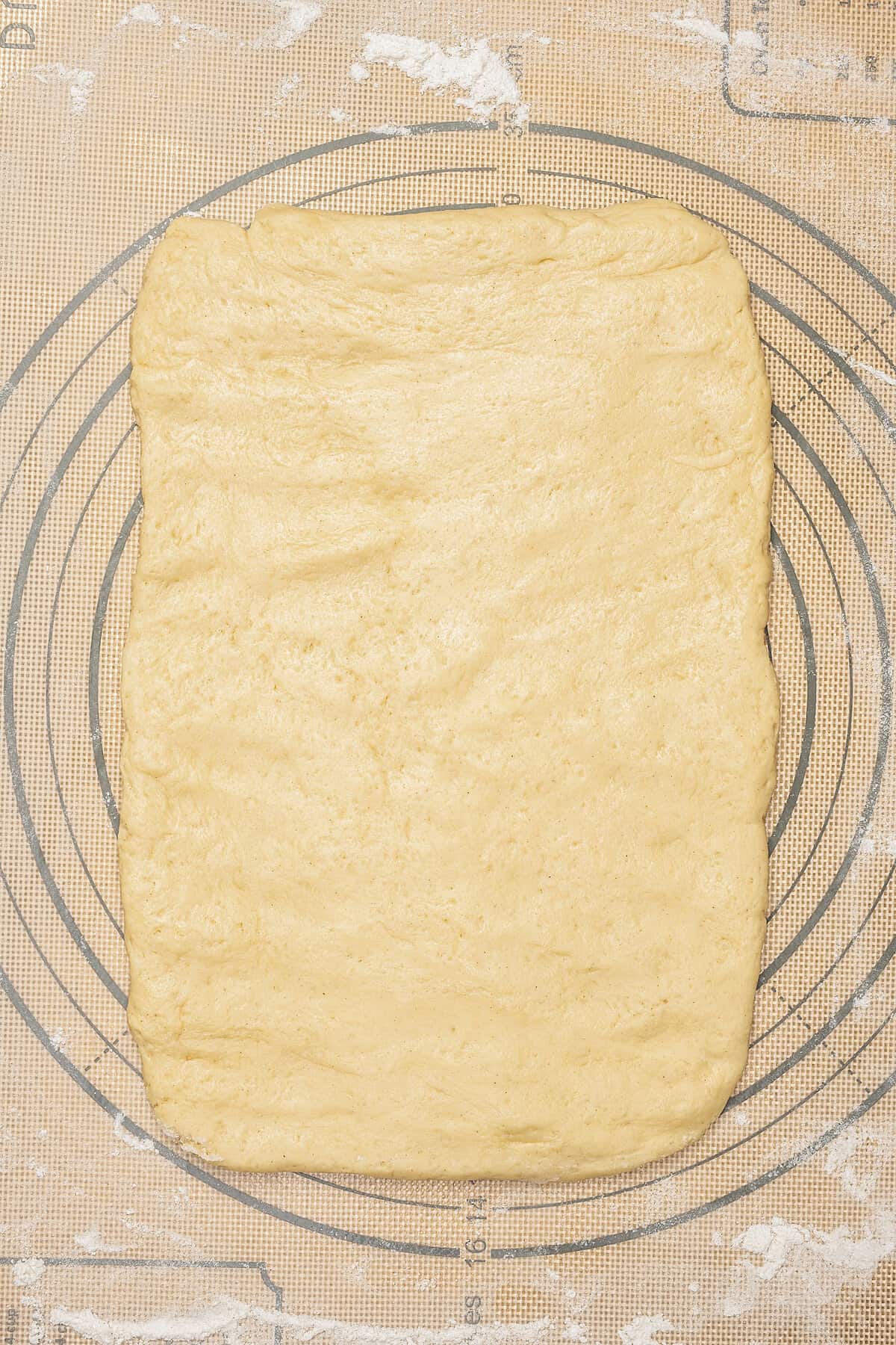 Gluten-free honey bun dough rolled out into a large rectangle.