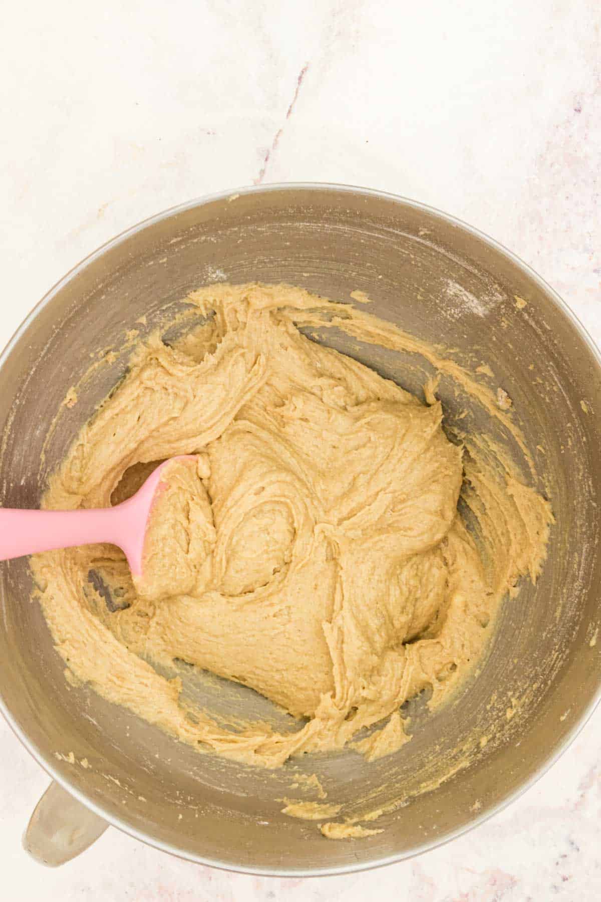 Cookie dough batter comes together in a mixing bowl.