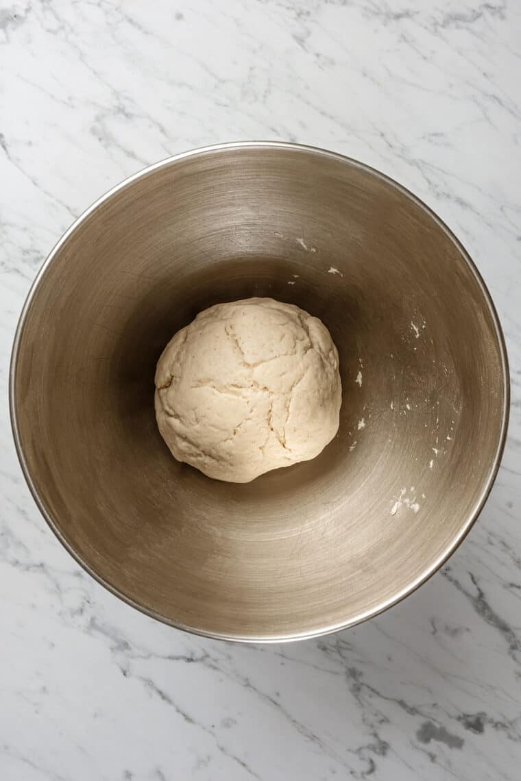 A ball of gluten-free bao bun dough in the bottom of a mixing bowl.