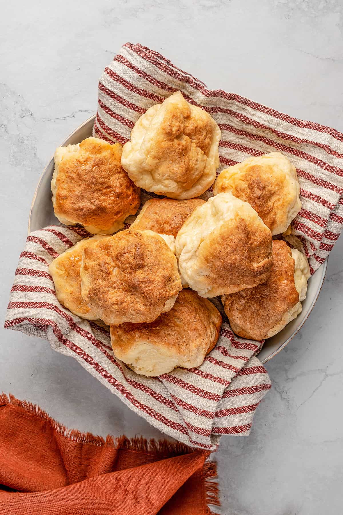 Gluten-free Hawaiian rolls piled in a cloth-lined bowl.