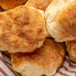 Close up of gluten-free Hawaiian rolls piled in a cloth-lined bowl.