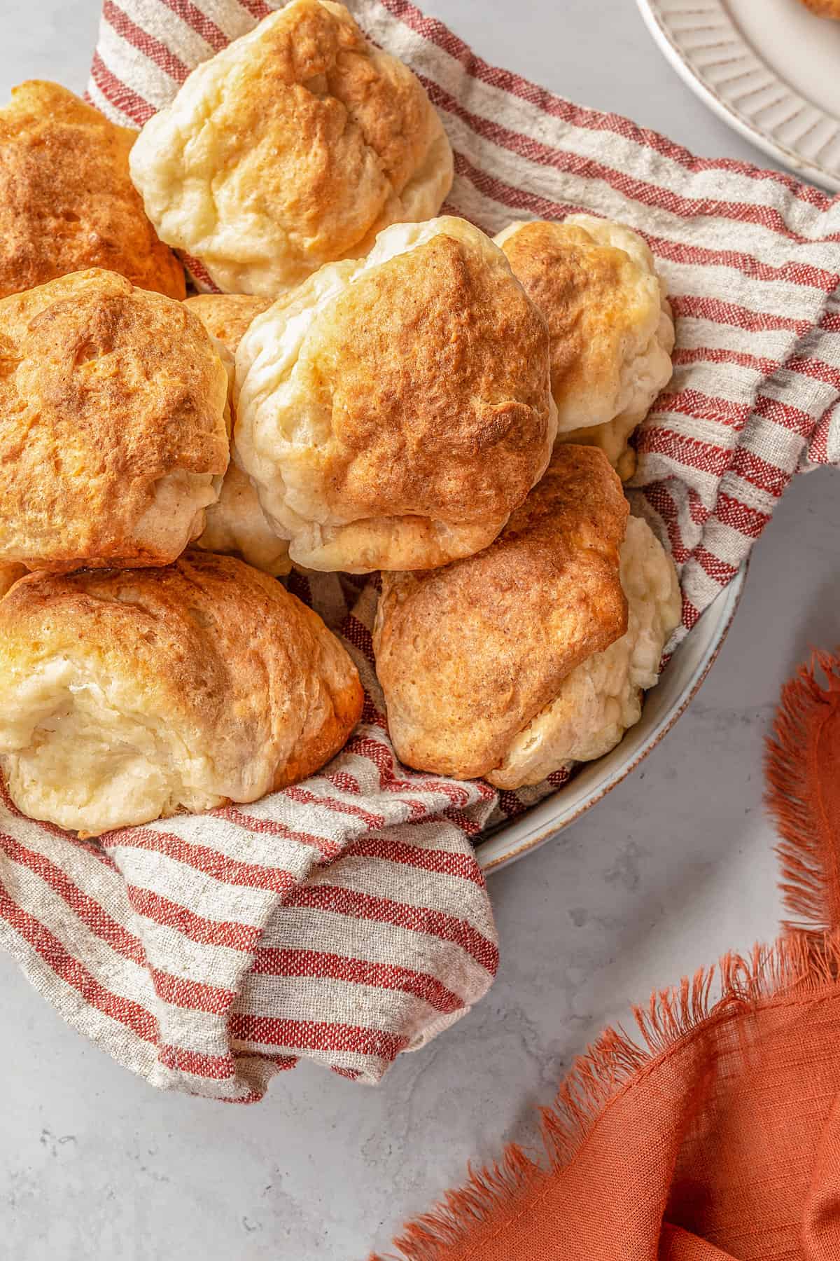 Gluten-free Hawaiian rolls piled in a cloth-lined bowl.