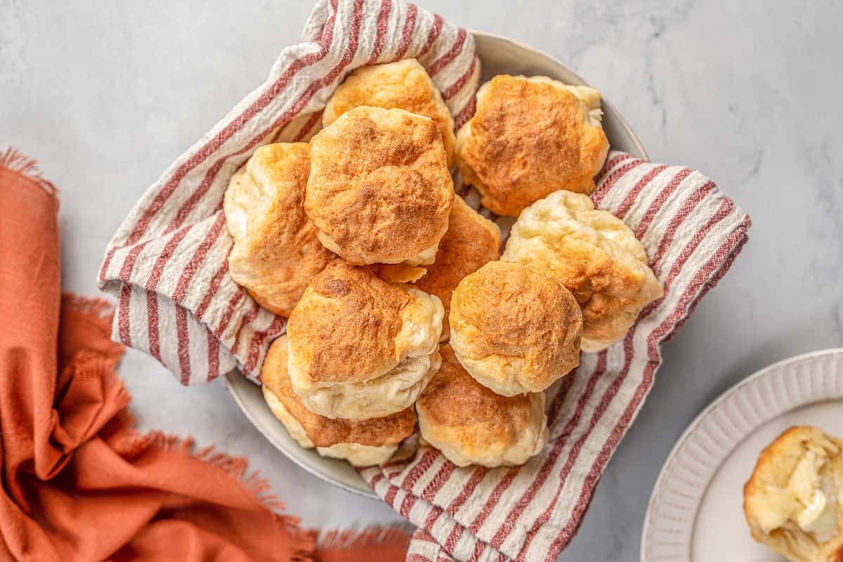 Gluten-free Hawaiian rolls piled in a cloth-lined bowl.