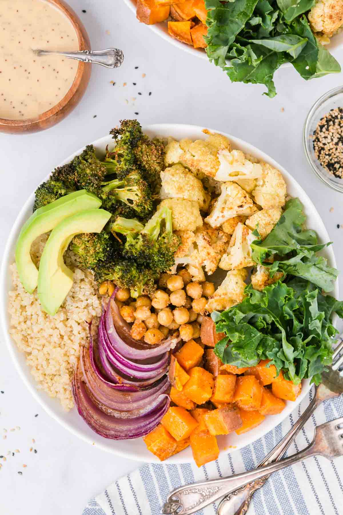 Overhead view of a sweet potato buddha bowl with roasted veggies, chickpeas, broccoli, kale, and quinoa.