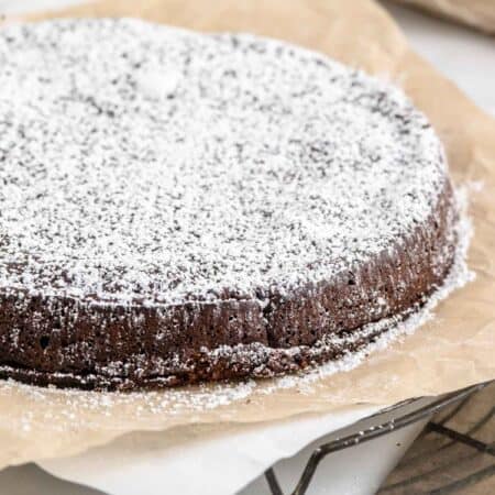 Flourless chocolate torte on a sheet of parchment paper.