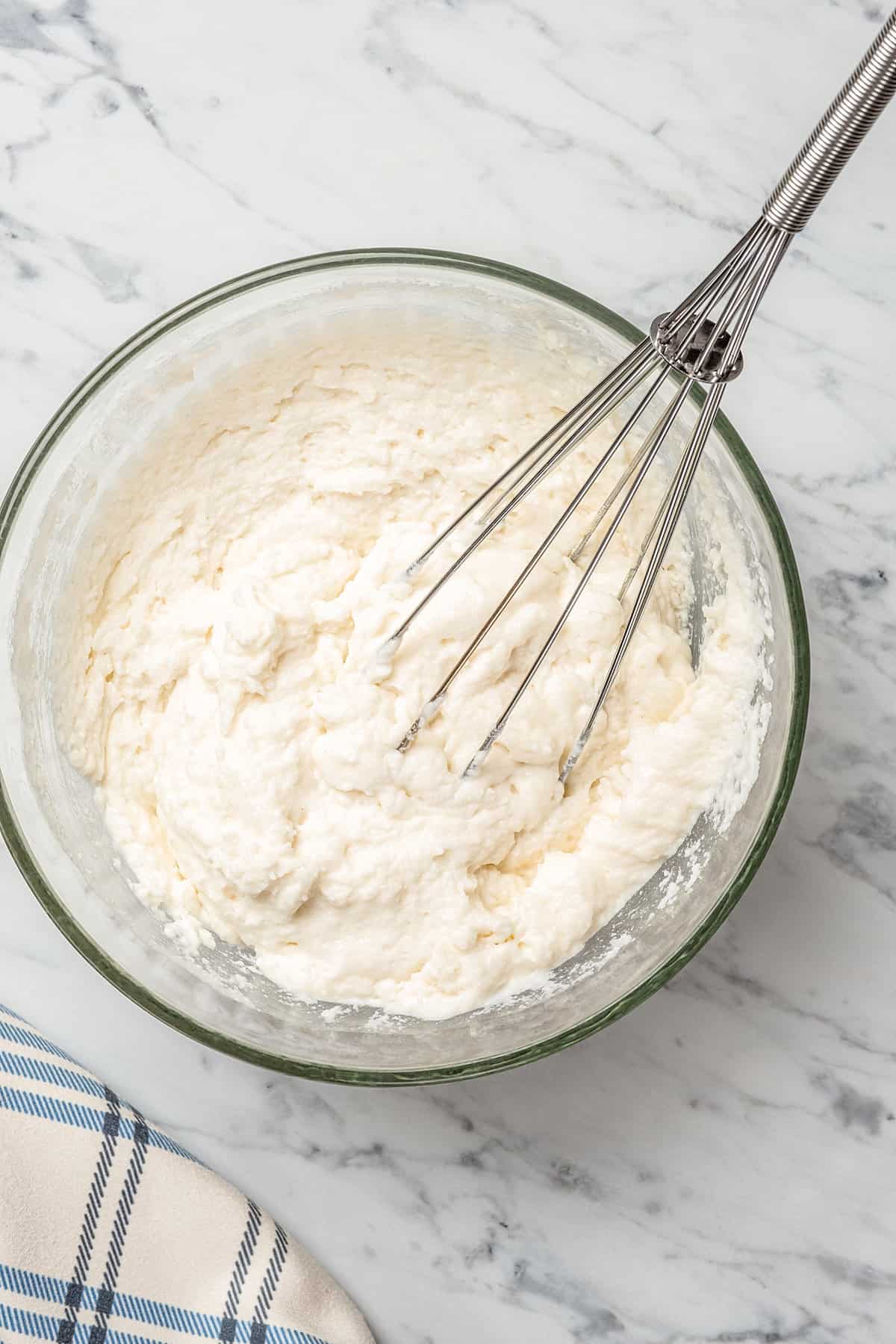 Gluten-free dumpling batter combined in a mixing bowl with a whisk.