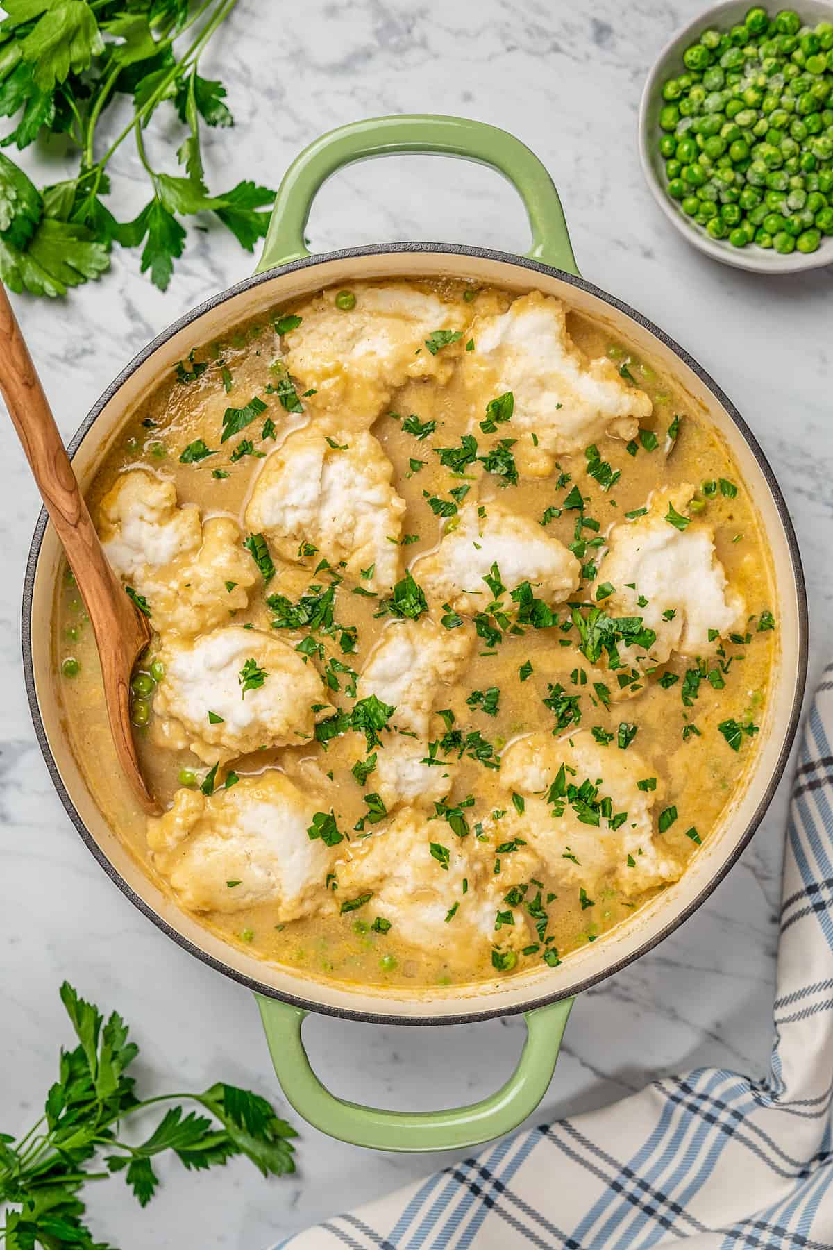 Finished gluten-free chicken and dumpling soup inside a large pot, garnished with fresh chopped parsley.