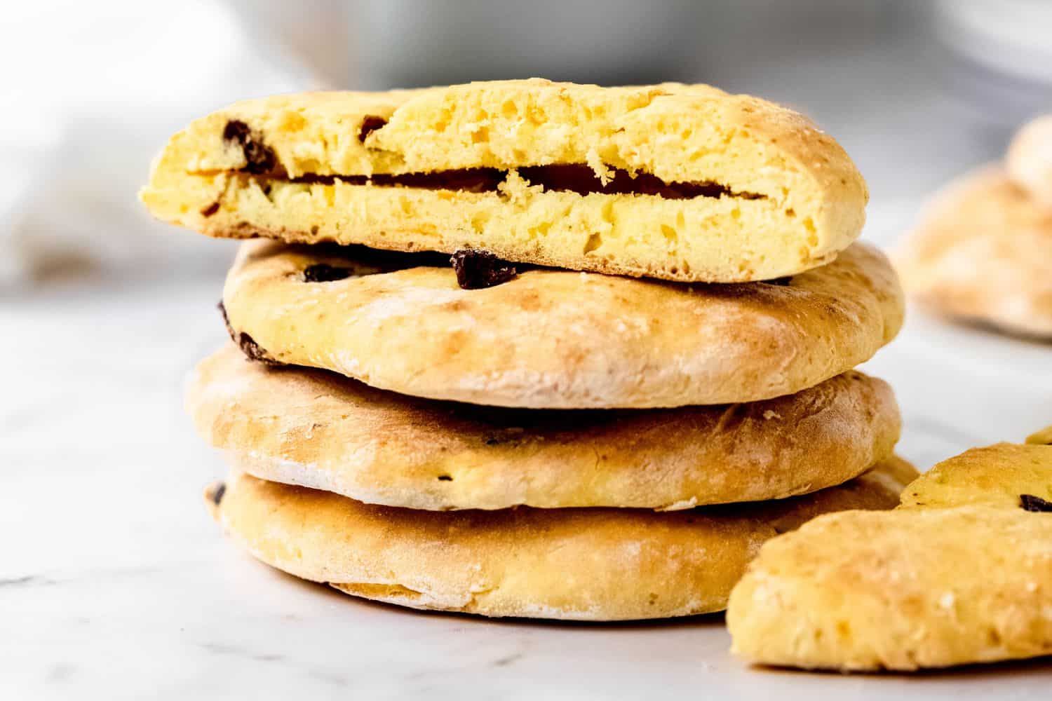 A stack of three gluten free cranberry orange pita with another half of one on the top of the pile and one half to the side.