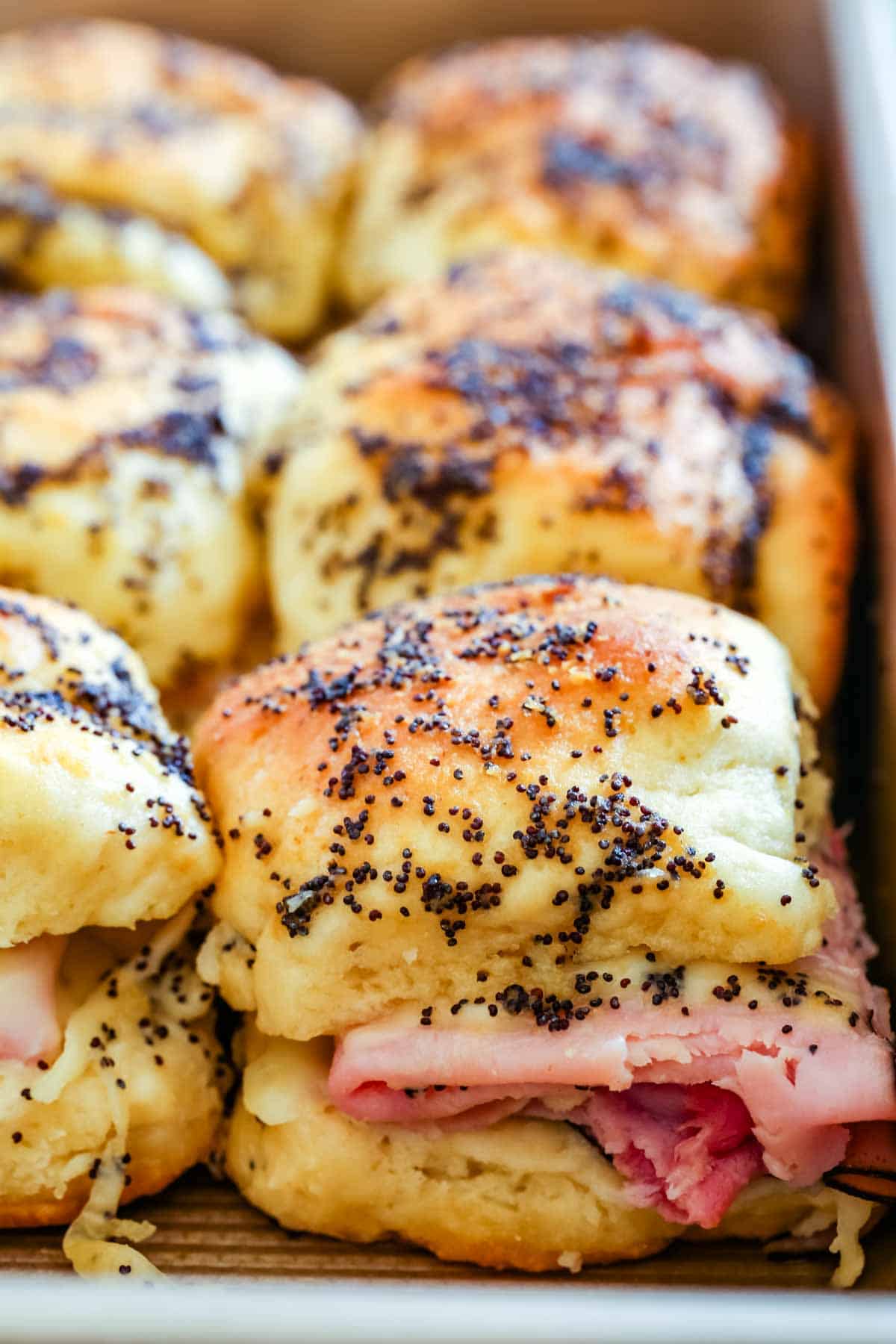 Gluten-free ham and cheese sliders in a baking pan.