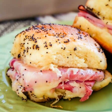 Close up of a gluten-free ham and cheese slider on a green plate.