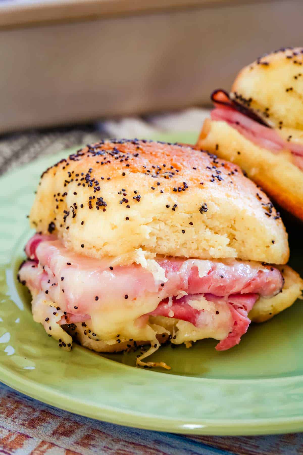 Close up of a gluten-free ham and cheese slider on a green plate.